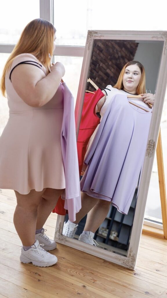 Plus-size woman trying on a dress in a fitting room