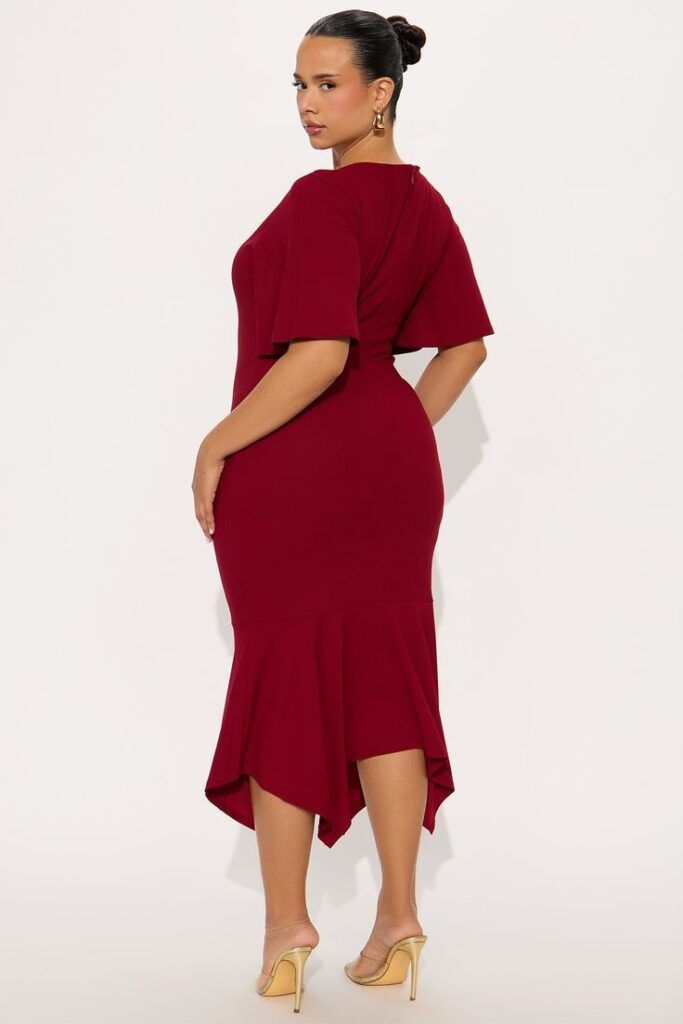 Curvy woman wearing an asymmetrical midi dress with a unique hemline.