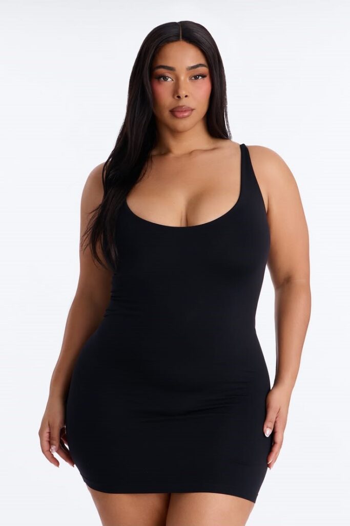 Curvy woman wearing a bodycon little black dress for an evening event.