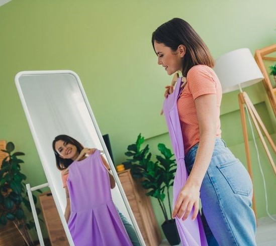Woman checking how a dress fits in a full-length mirror