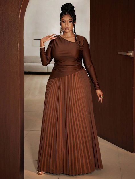 Plus-size woman wearing a chocolate brown pleated maxi dress with a fitted bodice.