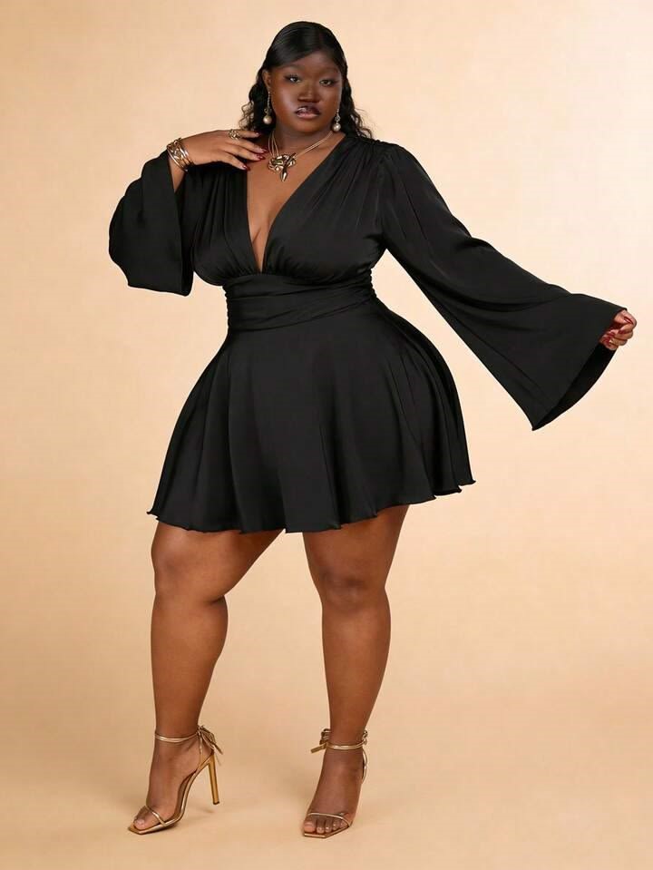 Plus-size woman with an hourglass body shape wearing a black fit-and-flare dress that highlights her defined waist.