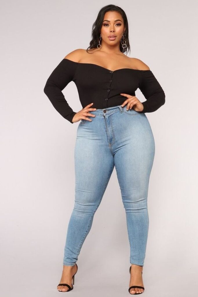 Plus-size woman with an hourglass body shape wearing an off-the-shoulder black top and high-waisted skinny jeans.