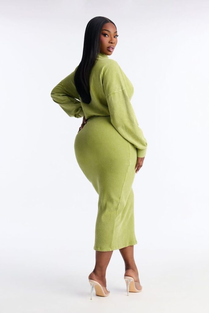 Curvy woman wearing a ribbed knit midi dress with ankle boots and a long coat