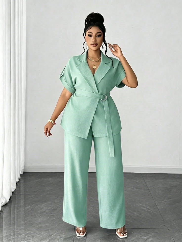 Plus-size woman wearing a matching mint green trouser set with a relaxed belted blazer for a comfortable office outfit.