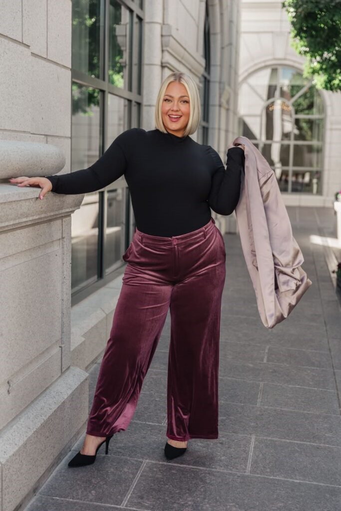 Woman wearing a mock neck top with velvet wide-leg trousers for an elegant fall outfit idea.