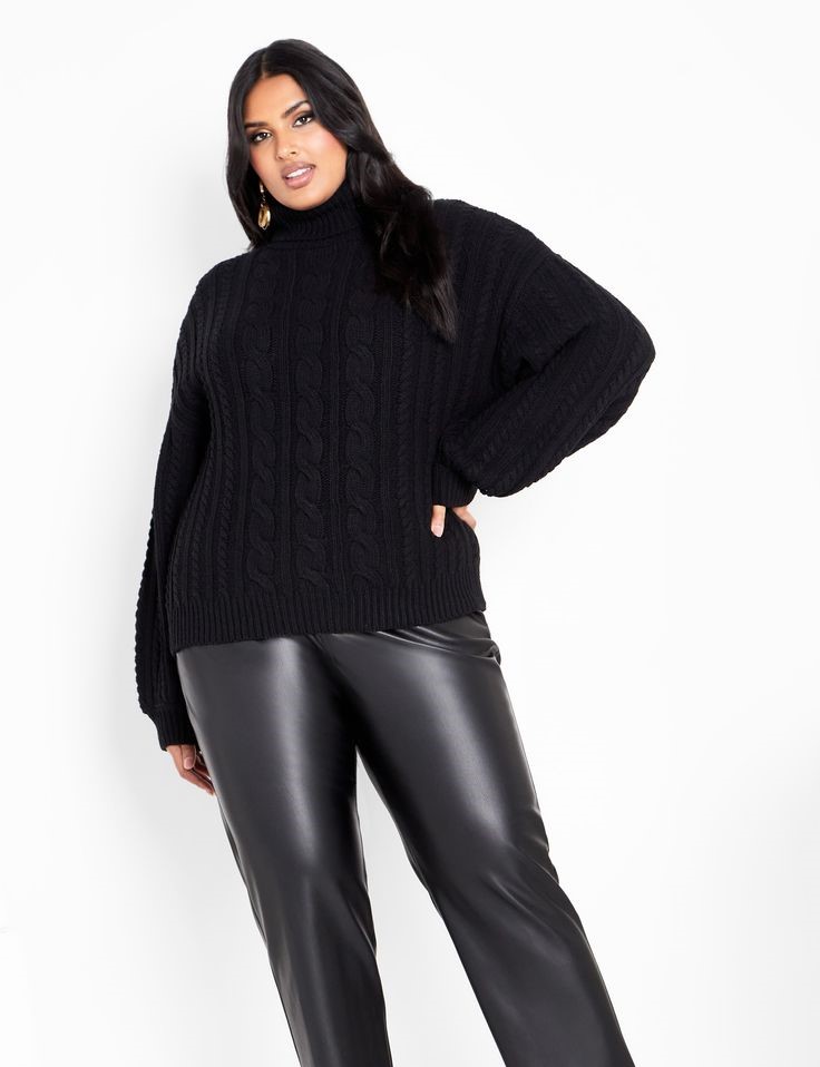 Plus-size woman wearing a black cable-knit sweater with faux leather leggings for a stylish rainy-day outfit.