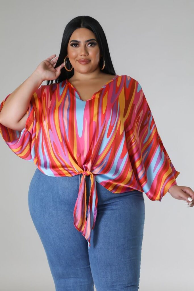 Plus-size abstract print tie-front top paired with blue jeans to show how to wear bold prints with confidence.
