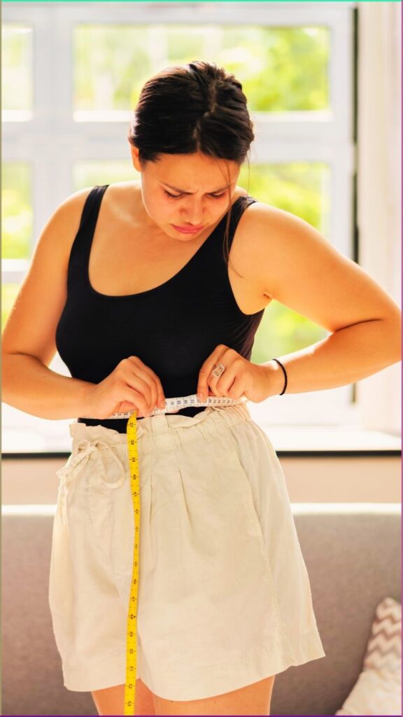 Woman measuring herself before buying a plus size maxi dress online.