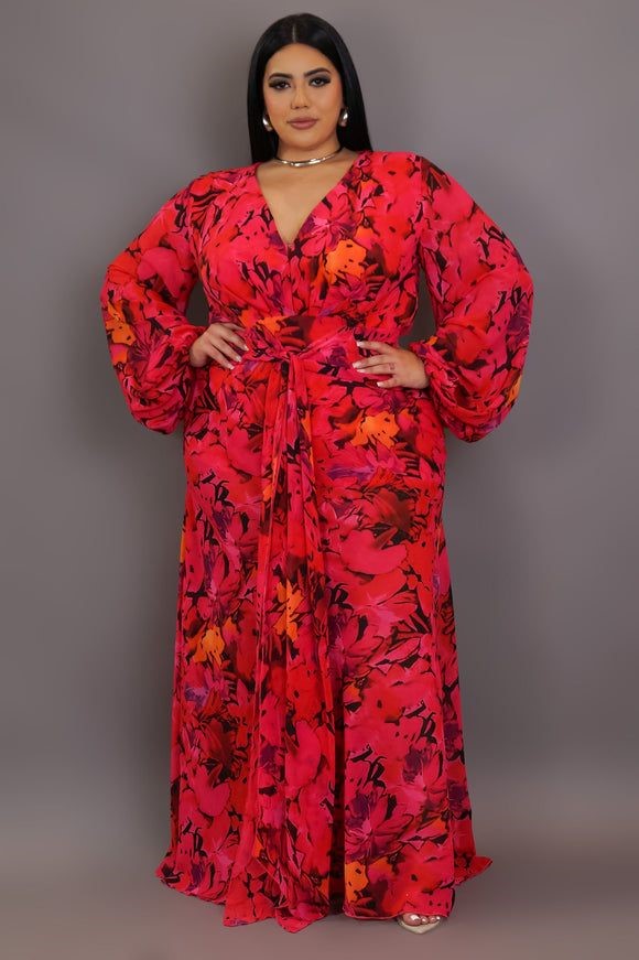 Plus-size woman wearing a bold red floral wrap maxi dress with minimal accessories and a confident style.