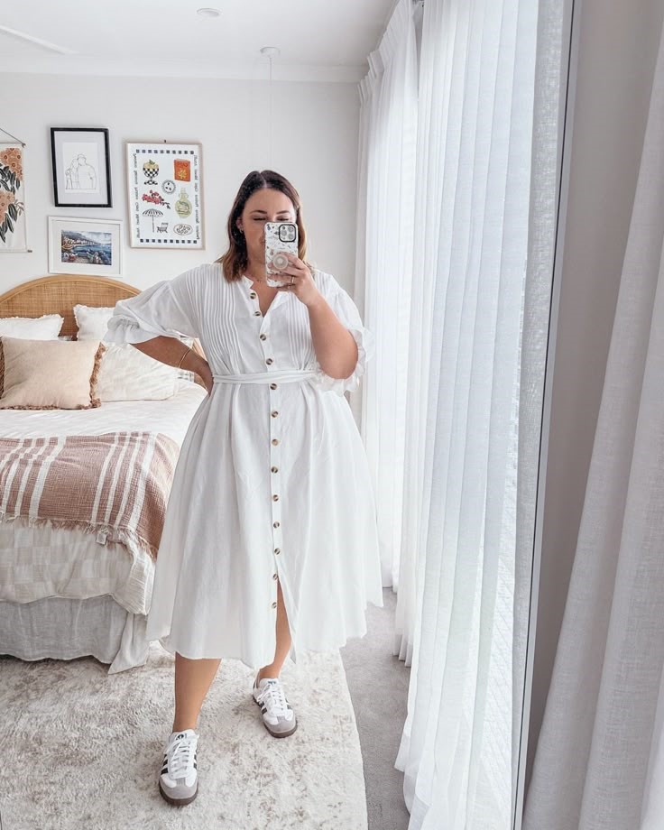 Plus size woman wearing a casual T-shirt dress with white sneakers.