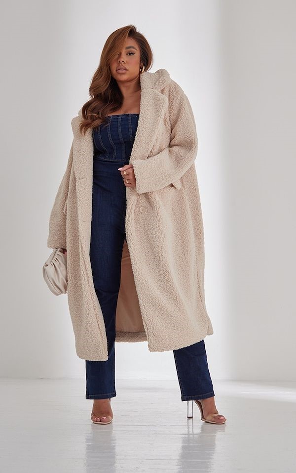Plus size woman wearing a teddy coat with dark wash denim for winter