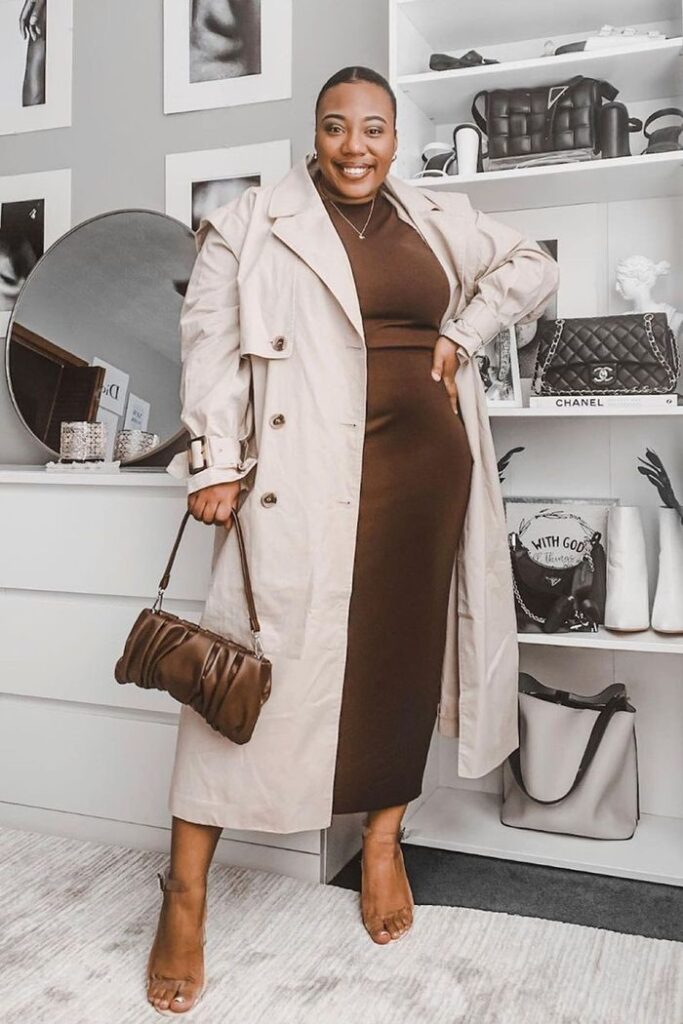 Plus-size woman wearing a beige trench coat over a brown midi dress for a chic rainy-day outfit.