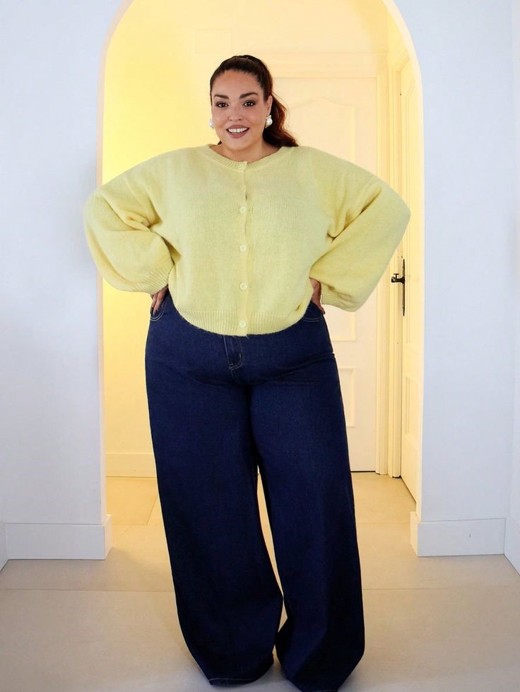 Plus-size woman wearing a puff sleeve blouse with wide-leg jeans.