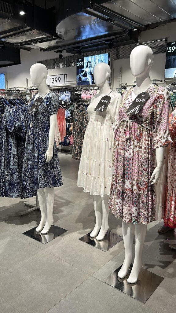 Plus-size dresses displayed in a clothing store, highlighting the importance of choosing quality over the lowest price.
