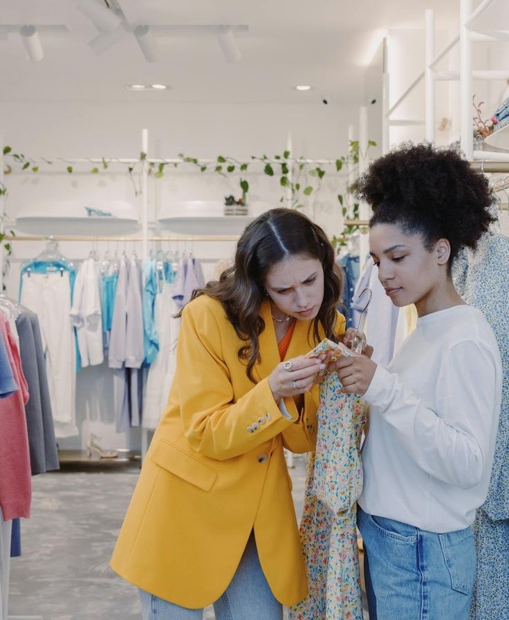 Checking a clothing label for fabric and care instructions before buying