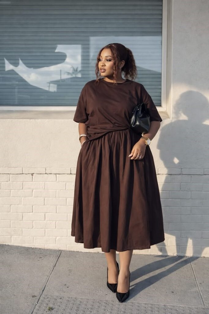 Plus-size woman wearing a relaxed brown midi dress with classic black pumps for a comfortable office outfit