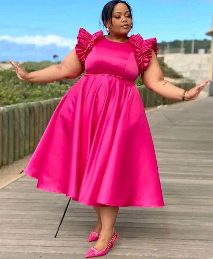 Curvy woman wearing a feminine ruffle midi dress with flowing details.