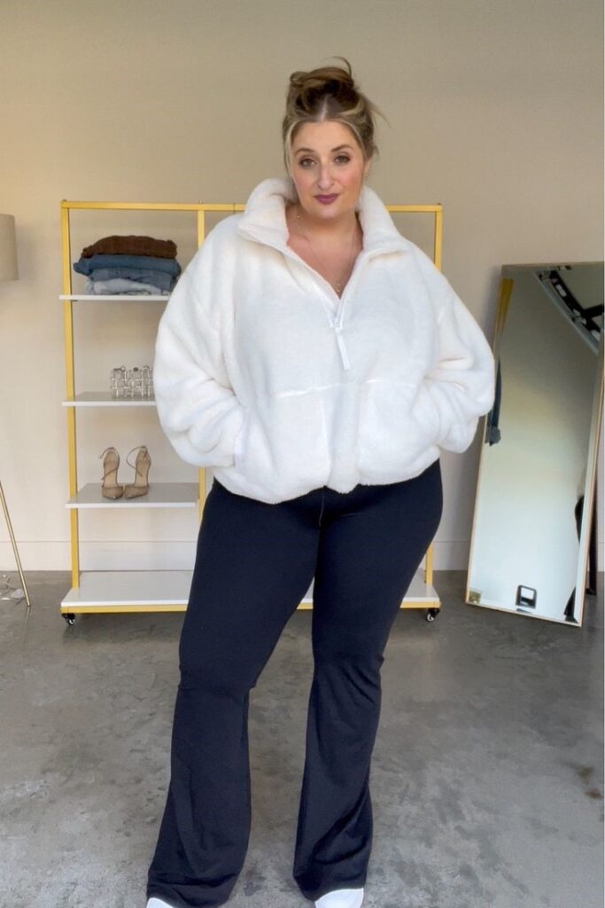 Woman wearing a sherpa pullover with flared knit pants for a cozy fall outfit idea.