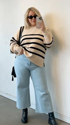 Plus size woman styling a striped sweater with wide-leg jeans