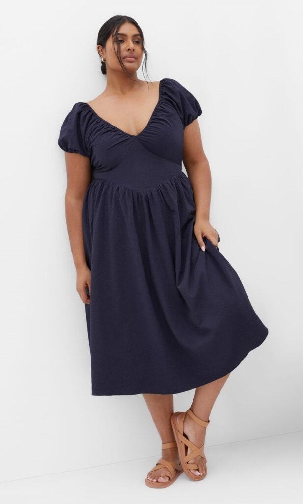 Curvy woman wearing an elegant V-neck midi dress with a flattering necklin
