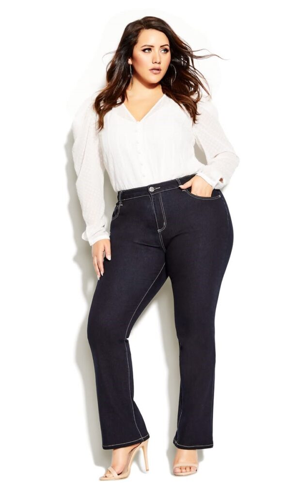 Woman wearing dark jeans with a white button-down shirt