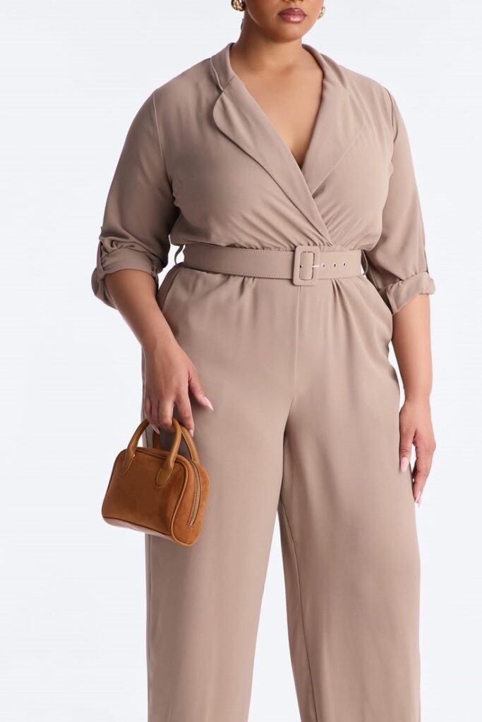 Woman wearing a taupe belted jumpsuit with a brown handbag
