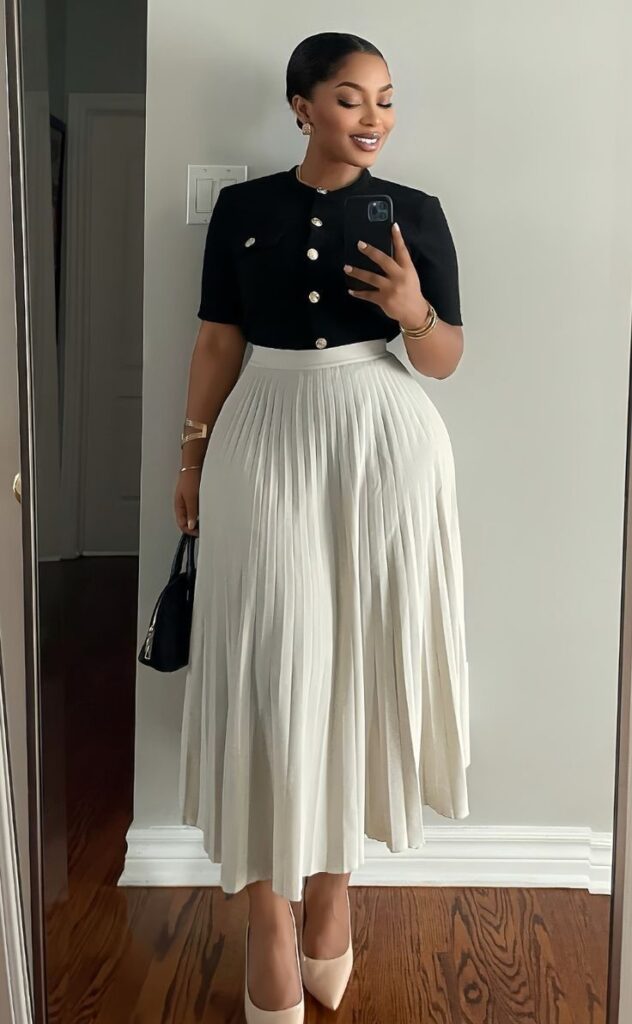 Plus size woman wearing a black top with a white pleated midi skirt