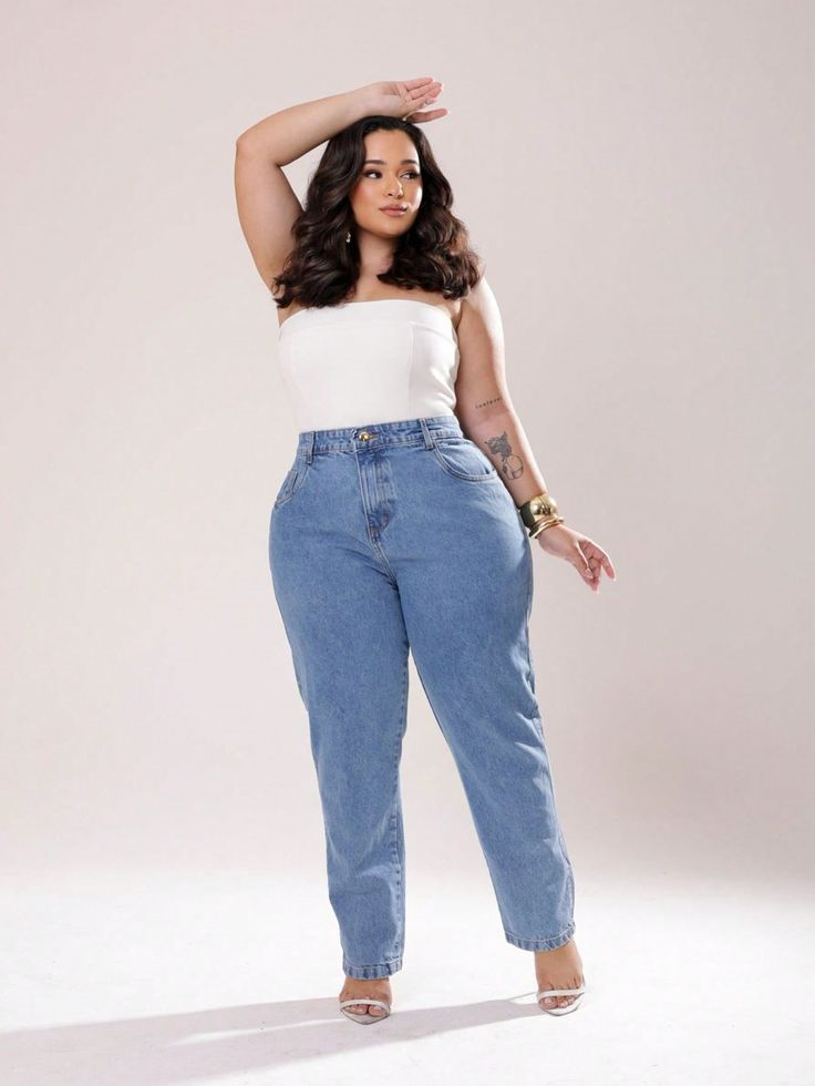 Woman wearing light blue high-waisted jeans with a white strapless top and heels