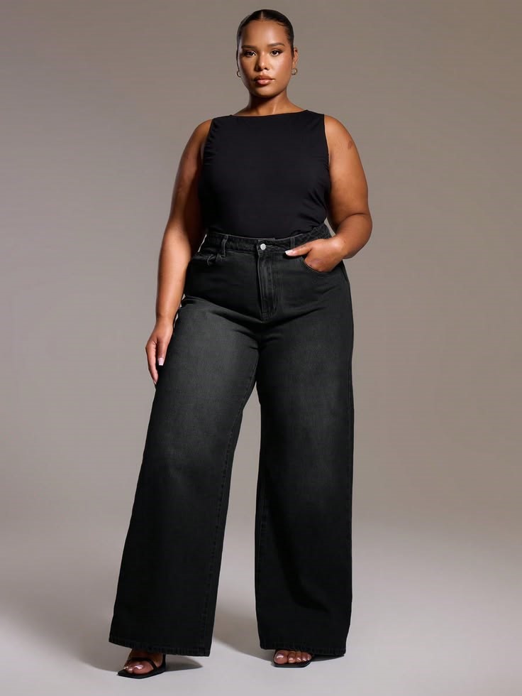 Woman wearing black wide-leg jeans with a sleeveless black top and sandals