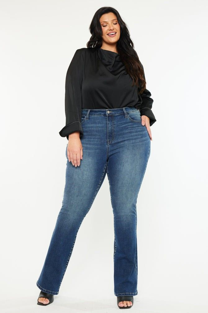 Woman wearing full-length blue jeans with a black blouse and heeled sandals
