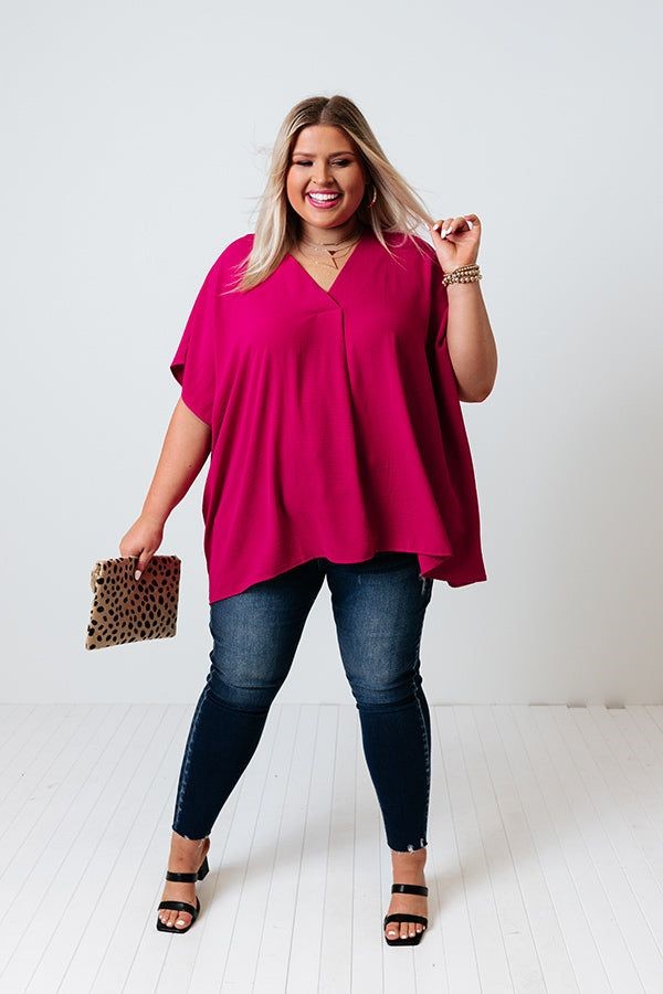 Best tops for an apple-shaped body, featuring a plus-size woman wearing a flattering V-neck tunic top.