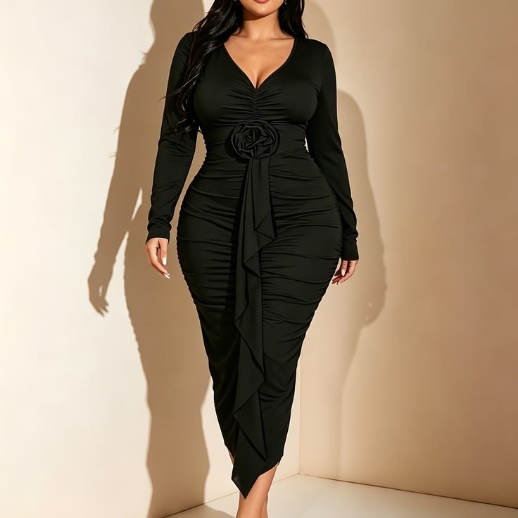 Hourglass plus size woman wearing a black midi dress with a defined waist and V-neckline