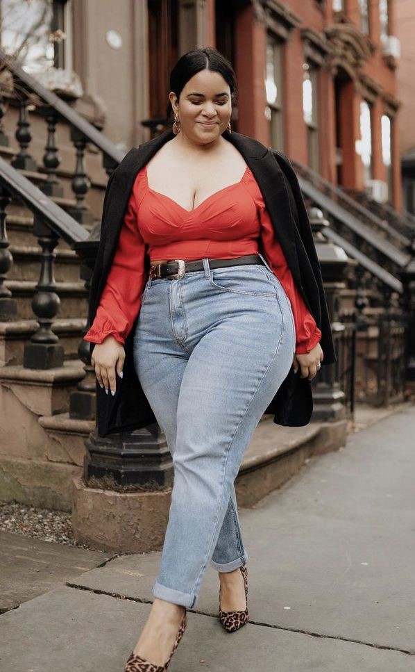 plus size woman wearing a fitted top, high-waisted jeans, and a structured blazer