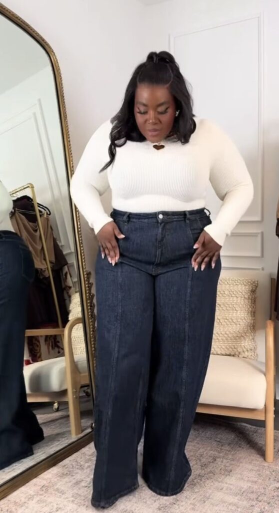 Plus size woman checking the fit of jeans around her waist and hips