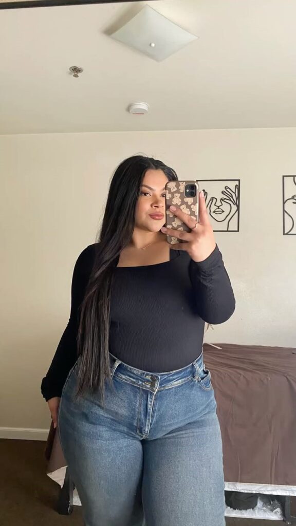 Curvy woman wearing light-wash wide-leg jeans with a fitted black top