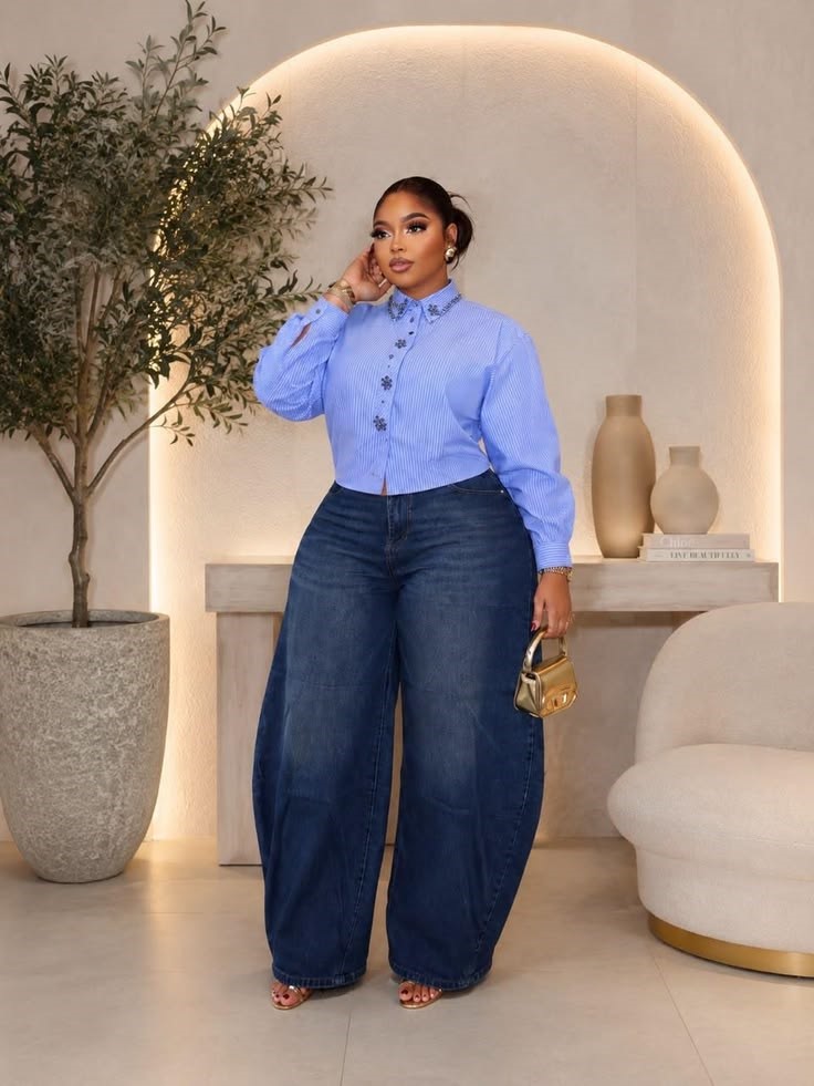 Plus size woman wearing dark wide-leg jeans with a blue blouse and heels