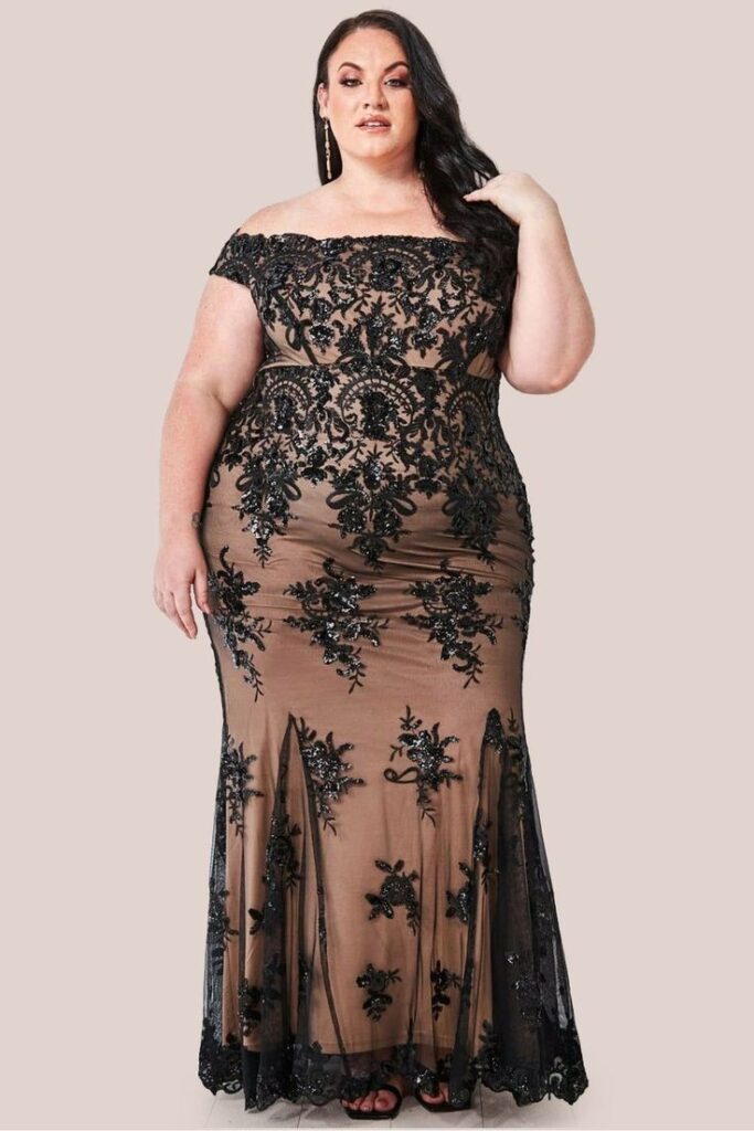 Pear-shaped plus-size woman wearing a black Bardot off-the-shoulder lace maxi dress.