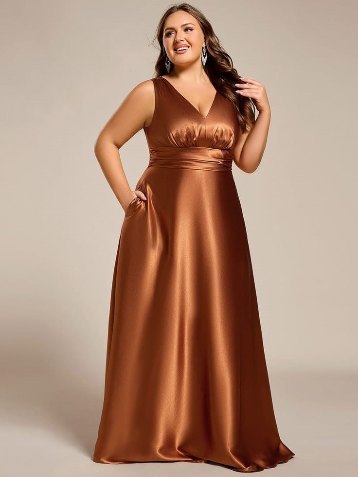 Pear-shaped plus-size woman wearing a bronze satin empire waist maxi dress with a flattering V-neckline.