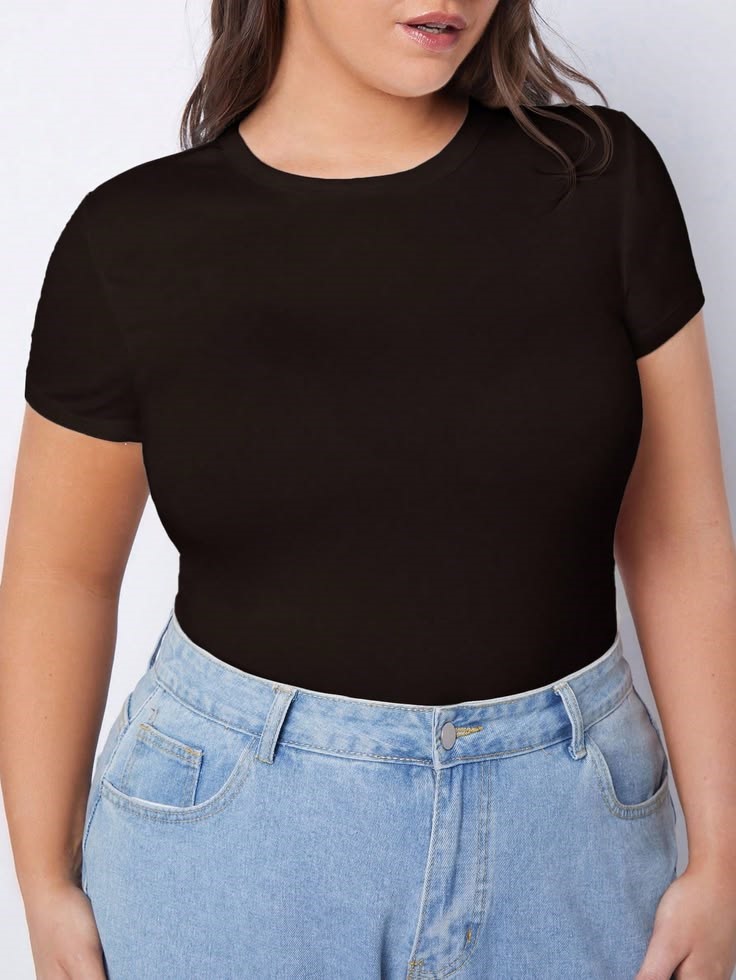 Plus size woman wearing a fitted black crew neck T-shirt as an example of 30 pieces that can create 100 outfits with light-wash high-waisted jeans