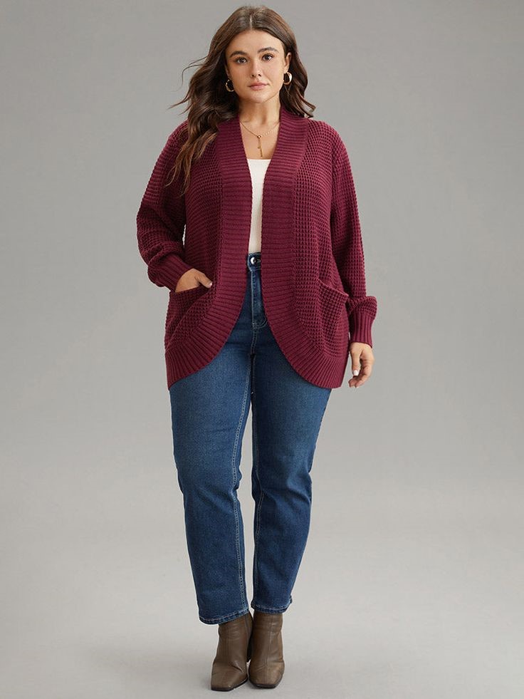 A woman wearing a cozy open-front cardigan with jeans 