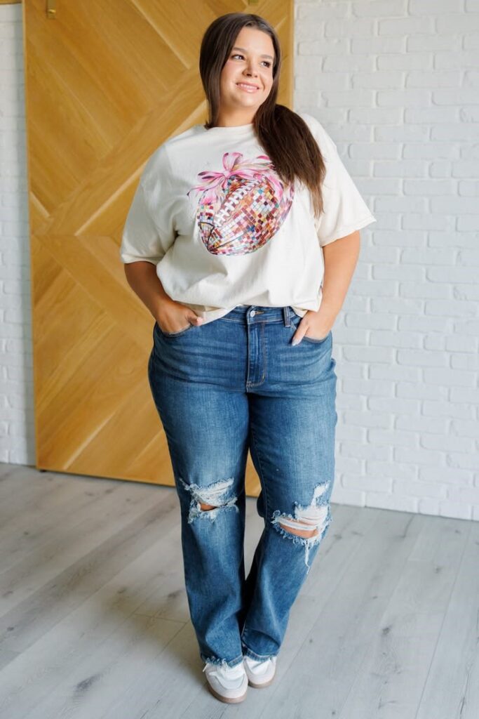 Plus size woman wearing a white graphic T-shirt with distressed blue jeans for a casual everyday outfit.