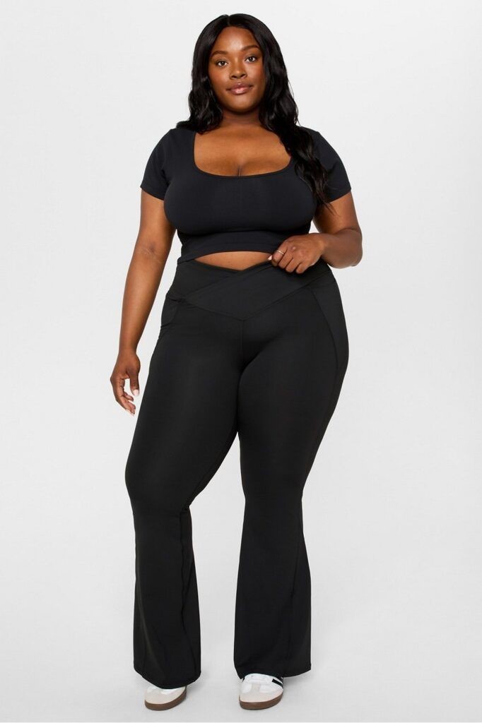 Plus-size woman with a rectangle body shape wearing a black activewear outfit.