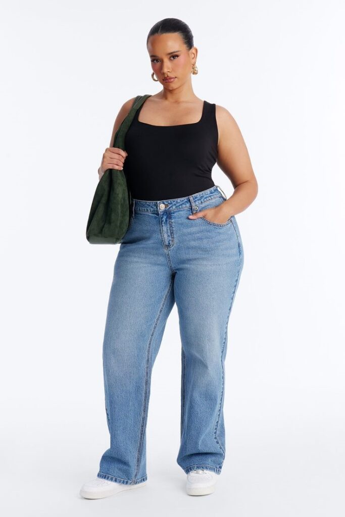 Curvy woman wearing straight-leg jeans with a black top