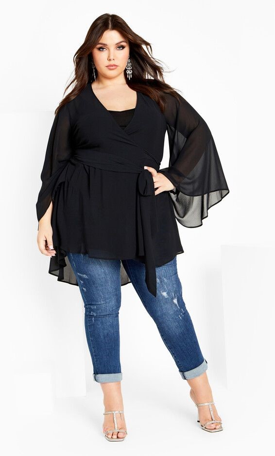 Apple-shaped plus size woman wearing a flowy V-neck tunic top with slim-fit jeans
