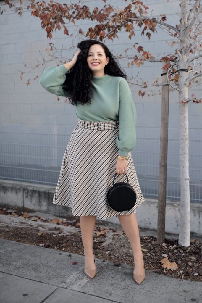 A woman wearing a versatile midi skirt styled with a knit sweater