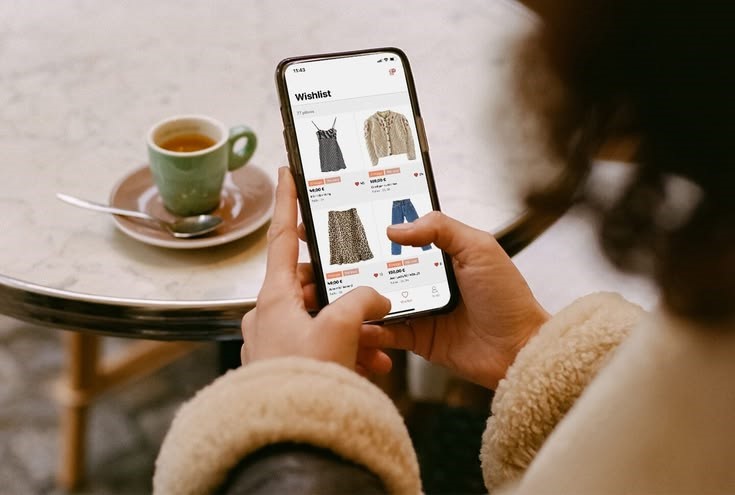 Woman browsing a fashion wishlist on her phone