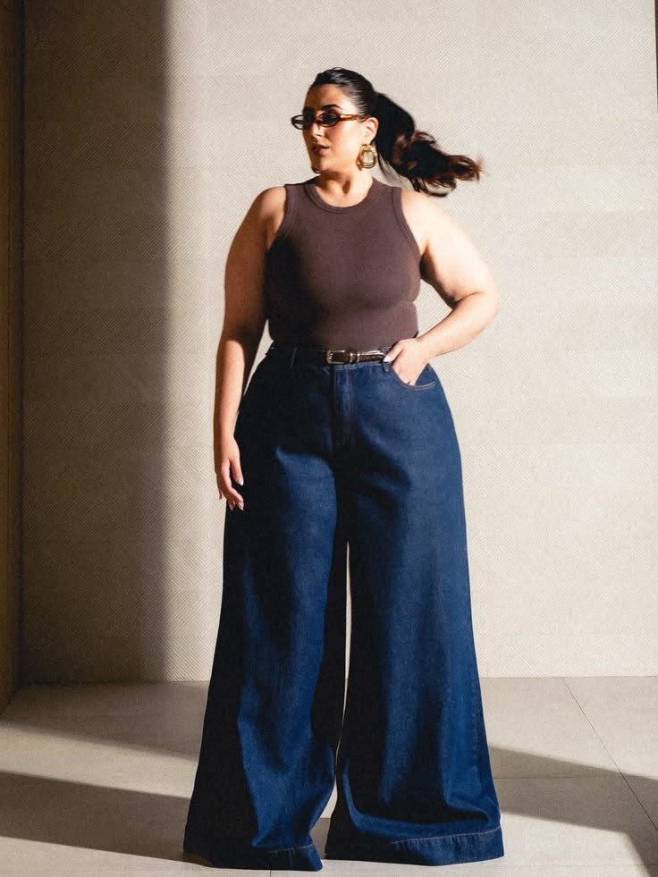 Confident plus-size woman wearing wide-leg jeans and a fitted sleeveless top