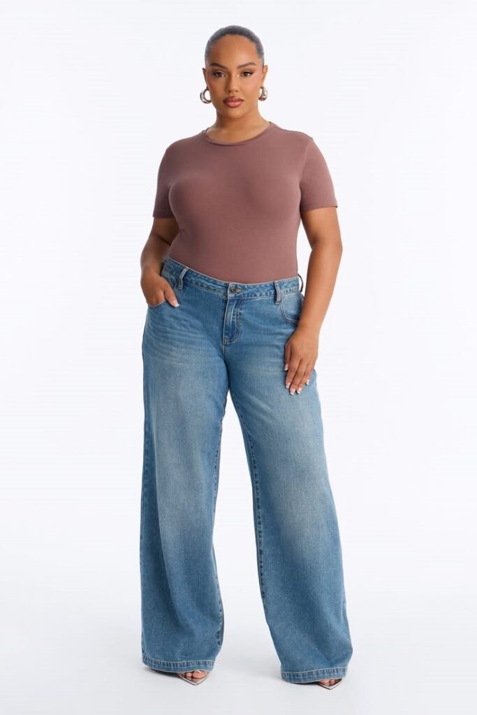 Plus-size woman wearing wide-leg jeans with a fitted brown knit top