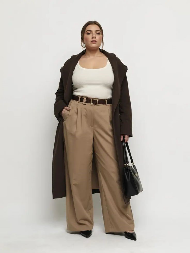 Plus size woman in a long coat, wide-leg trousers, and fitted top creating a balanced silhouette
